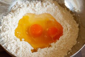 Bild von Eiern in Mehlmulde für den Ravioliteig