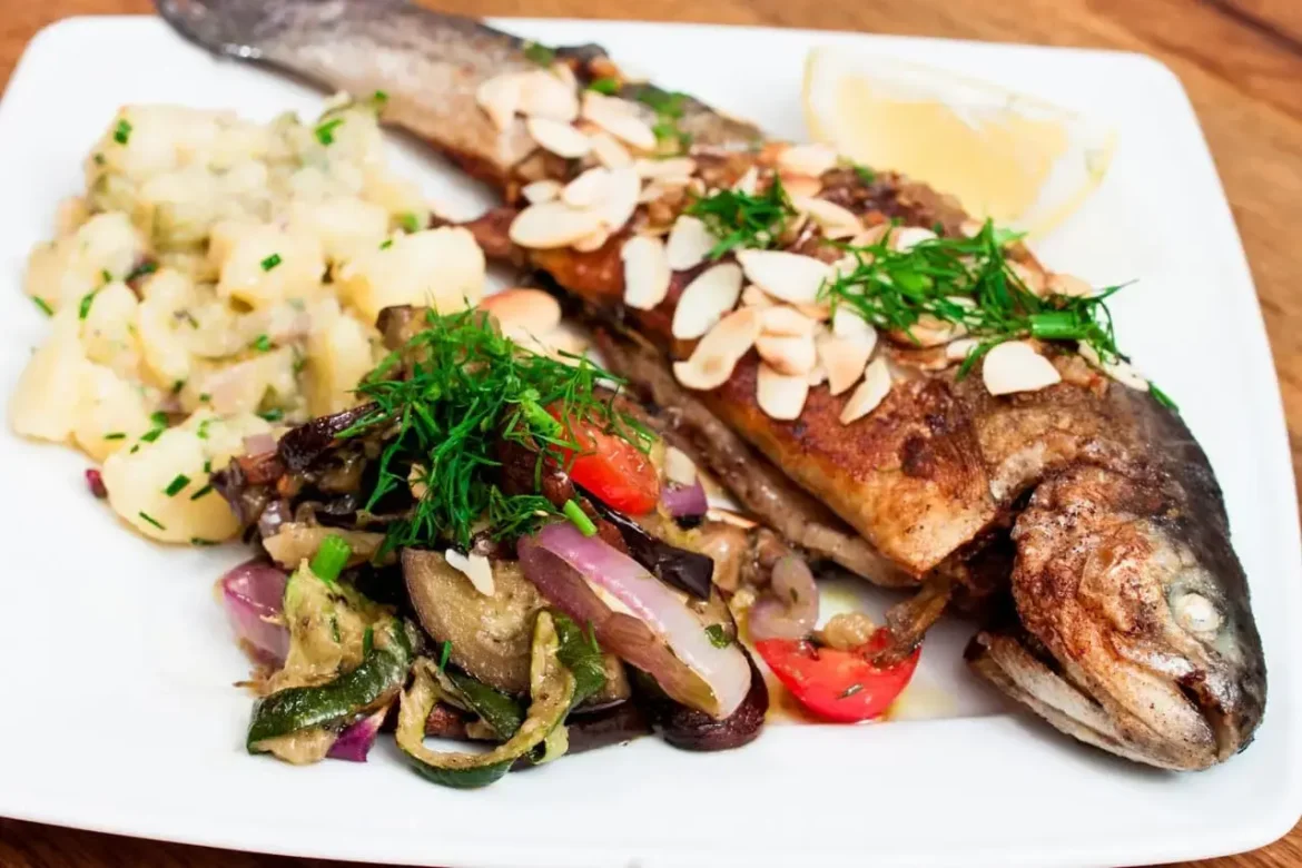 forelle-muellerin-rezept Forelle Müllerin auf einem Teller mit Kartoffelsalat und Ofengemüse