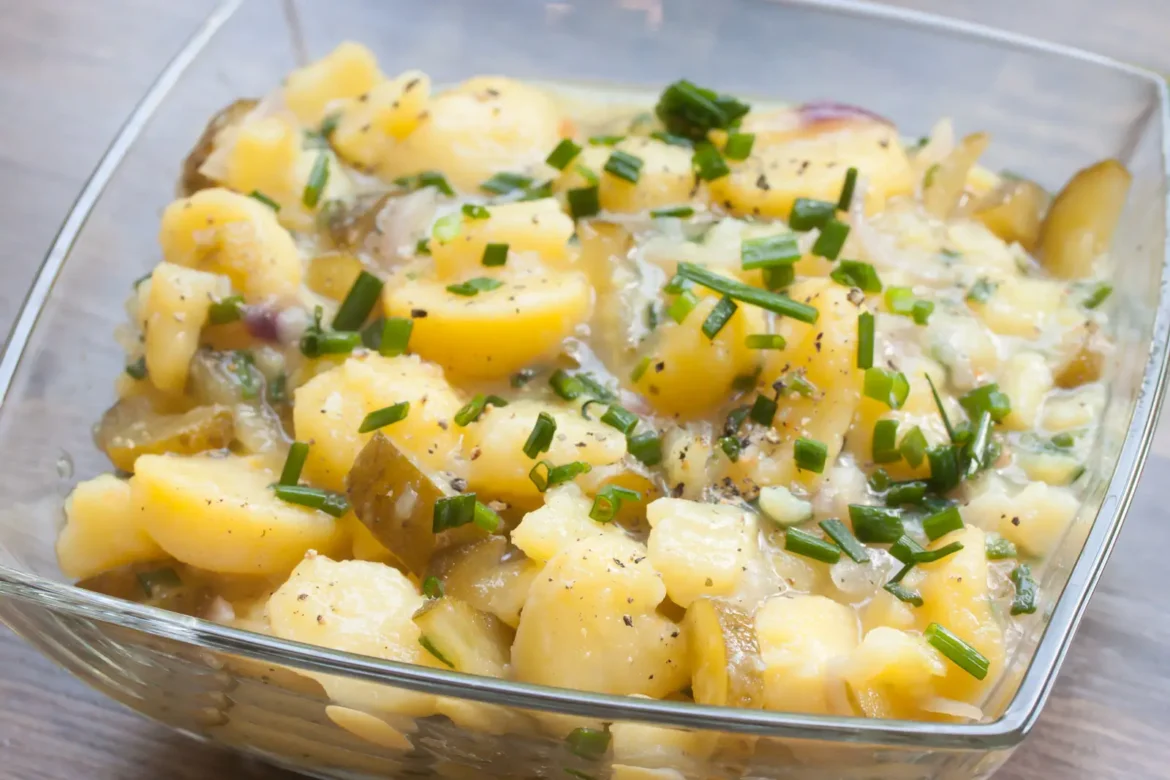 Kartoffelsalat mit Schnittlauch und sauren Gurken in einer Glasschale