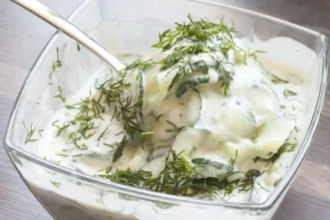 Ein fertiger Gurkensalat mit Joghurt und Dill in einer Glasschüssel